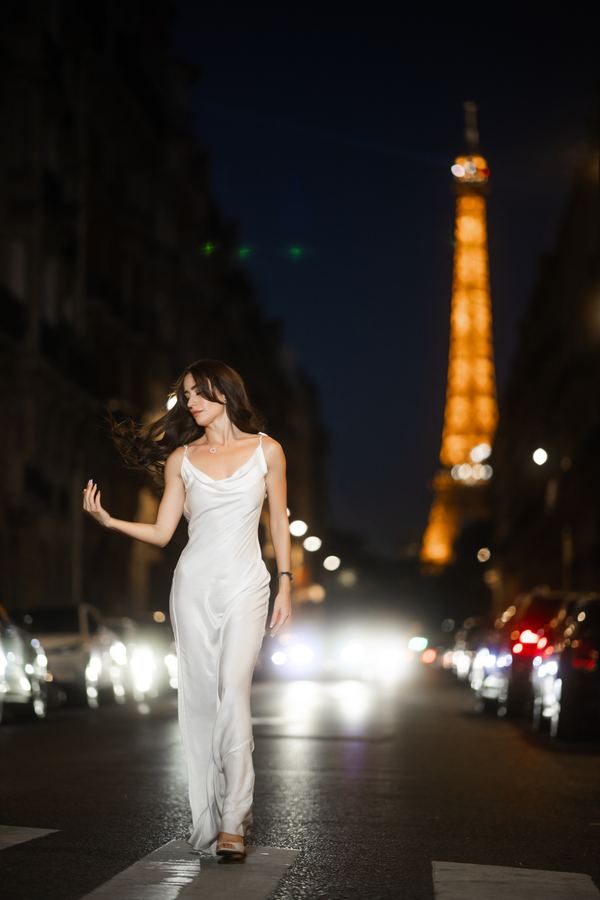 Portrait of a woman in white satin slip dress, clutch, Paris at night