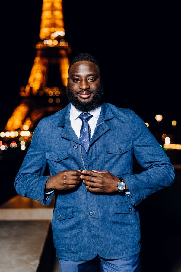 Portrait of a man in blue jacket, tie, Eiffel Tower, Paris at night