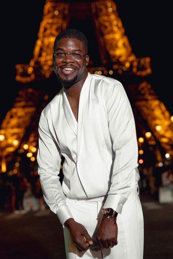 Portrait of a man in white shirt, white trousers, Eiffel Tower, Paris at night