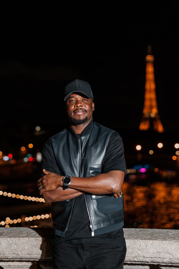 Portrait of a man in black leather vest, black tee, black cap, bridge over the Seine, Paris at night