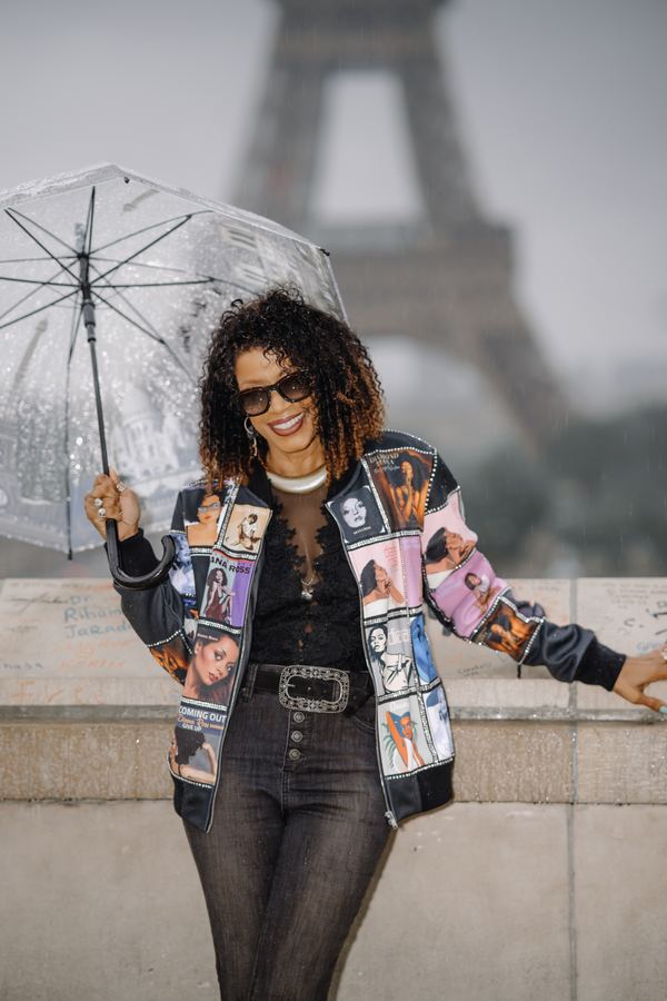 Portrait of a woman in printed bomber jacket, black flared trousers, sunglasses, transparent umbrella, trocadero terrace, Paris