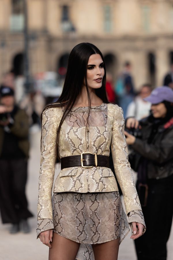 Portrait of a woman in python-print top, mini skirt, wide belt, louvre courtyard, Paris