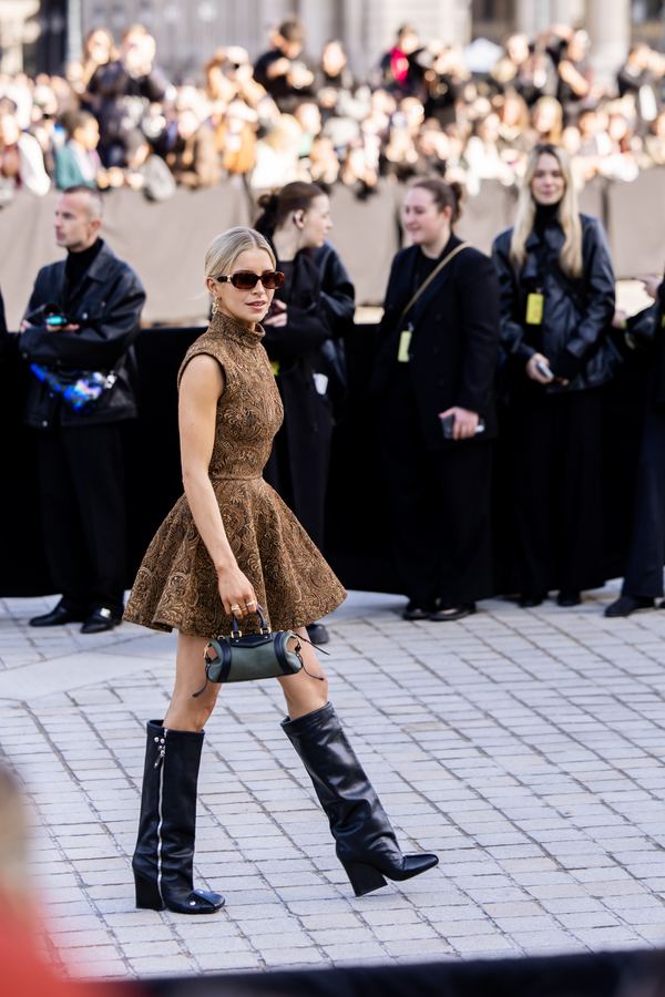 Street style at Paris Fashion Week: brown knit mini dress, black knee boots, sunglasses, show venue entrance, Paris