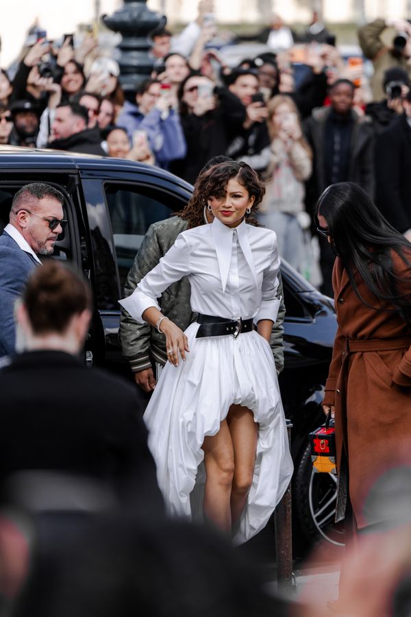 Street style: white high-low dress, black belt, show venue entrance, Paris