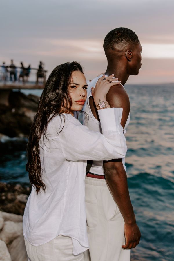 Couple, rocky coast at golden hour