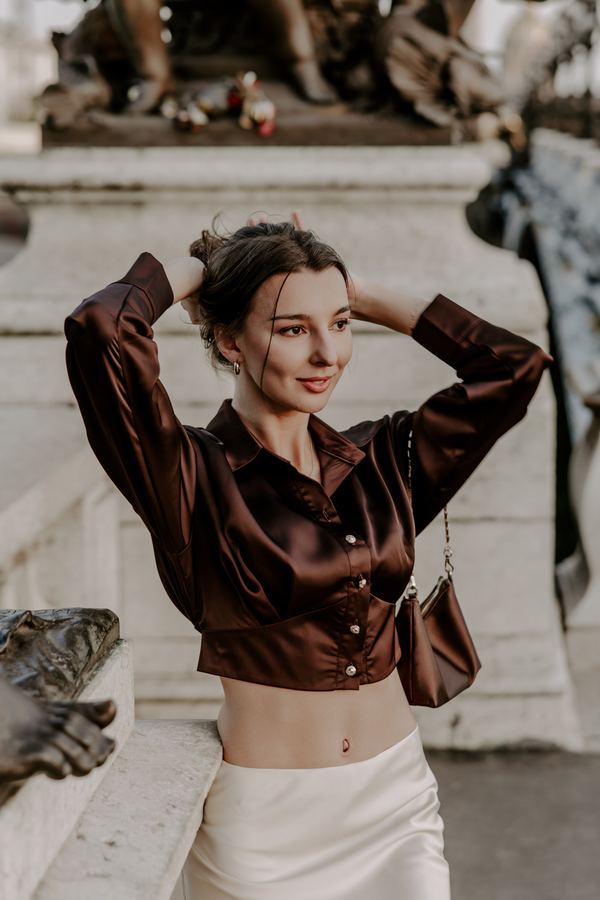 Portrait of a woman in brown satin blouse, cream skirt, Pont Alexandre III, Paris at golden hour