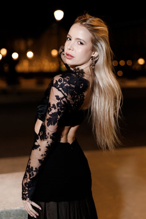 Portrait of a woman in black lace top, Louvre pyramid, Paris at night