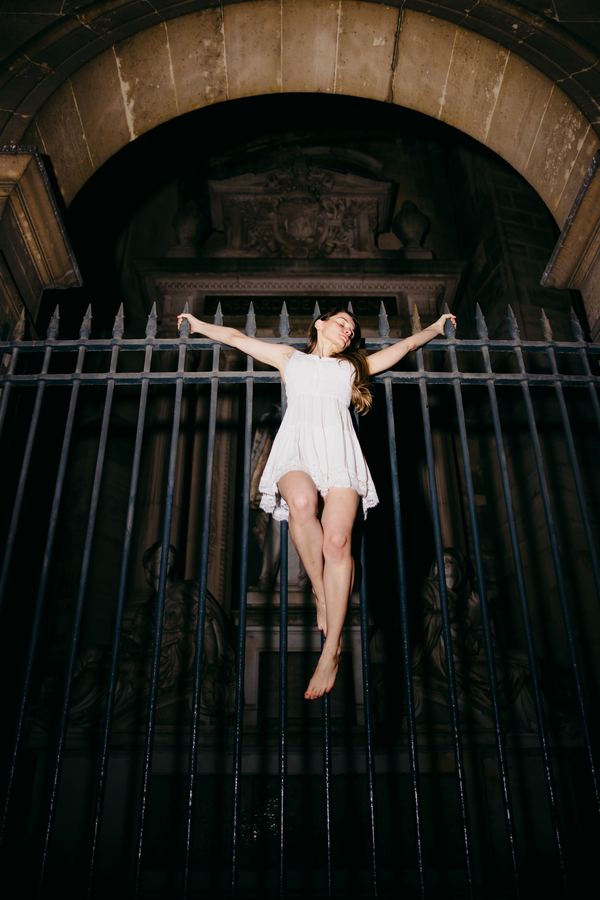 Portrait of a woman in white mini dress, louvre gate, Paris at night