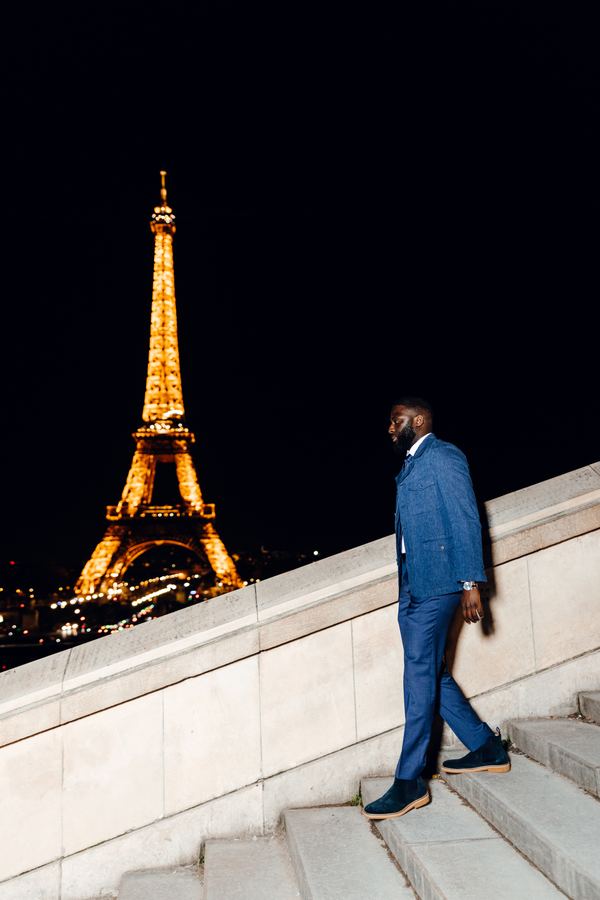 Portrait of a man in blue denim suit, tie, dark suede shoes, Trocadéro, Paris at night